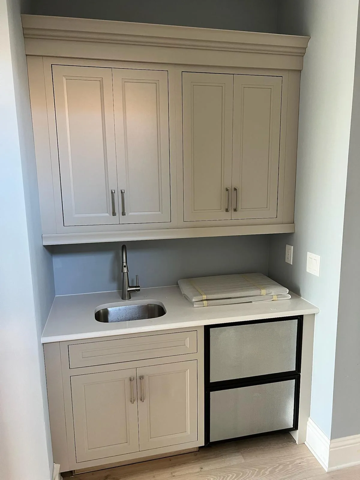 Cream inset bar cabinets with crown molding, undermount sink, quartz counter and two undercounter appliance drawers in Lakewood Ranch, FL