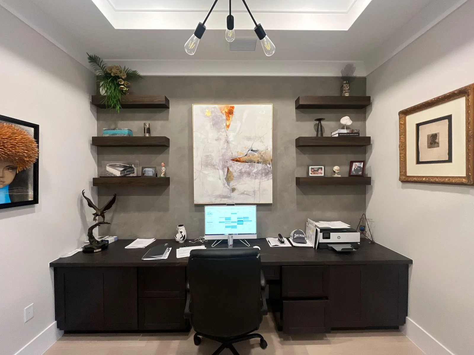 Gray polished accent wall behind a built-in walnut desk and floating shelves in a home office in Lakewood Ranch, FL