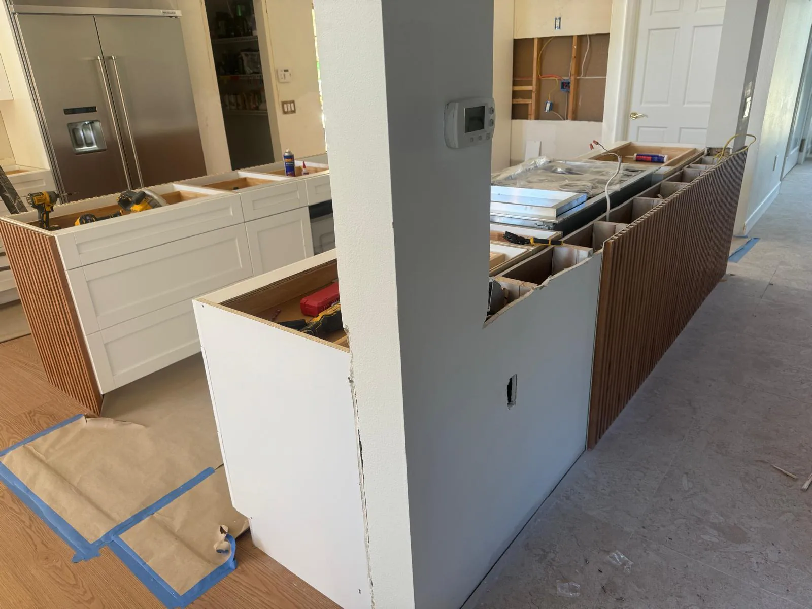 Peninsula cabinets being clad with wood slat panels, drawer boxes open and hand tools on top in Lakewood Ranch, FL