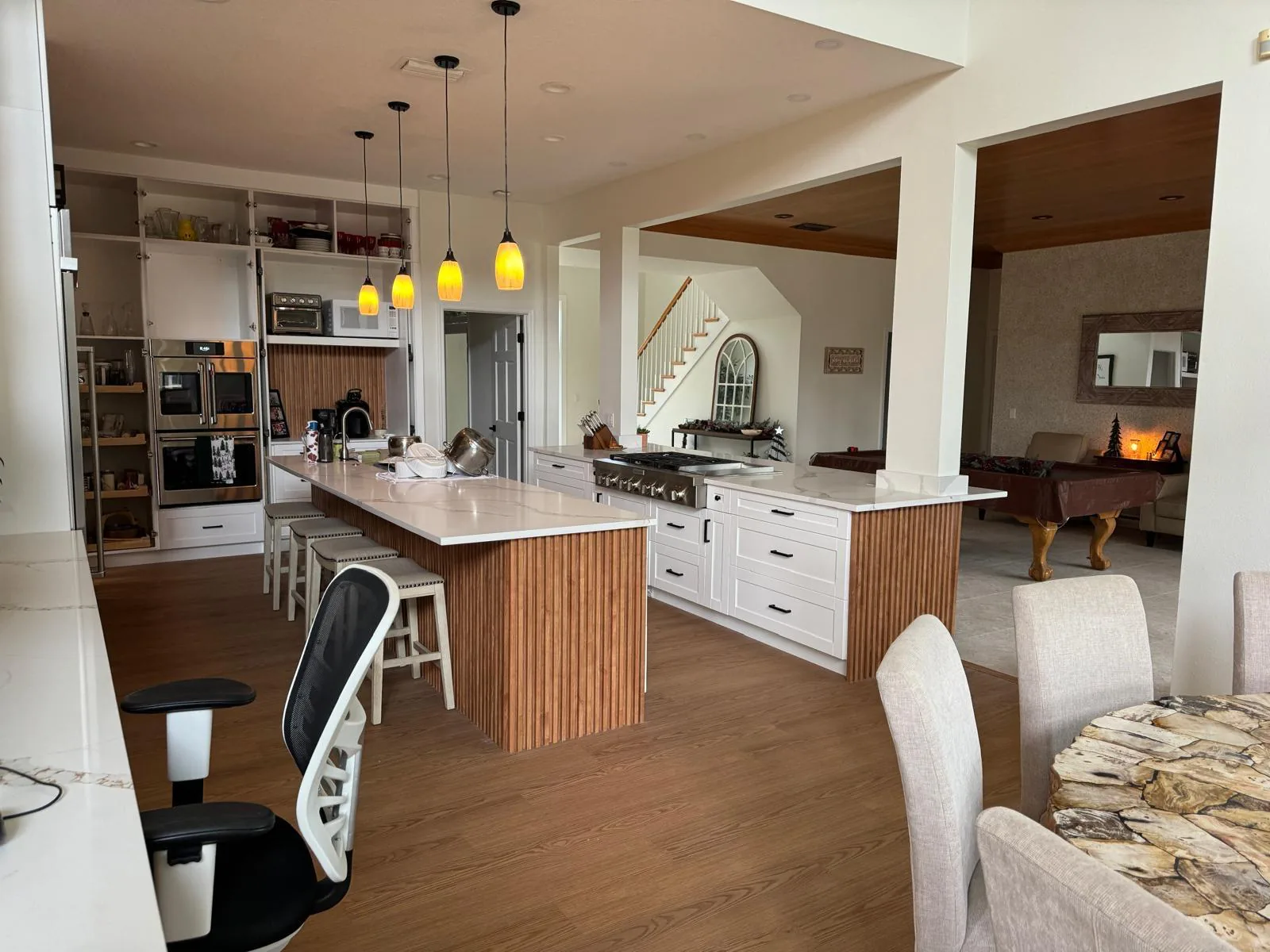 Open concept remodeled kitchen and living space with quartz island and pendant lights in Lakewood Ranch, FL